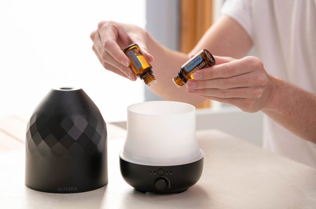 person putting essential oils into a diffuser